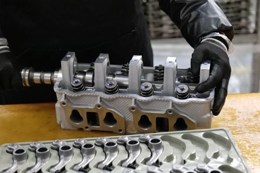 mains posant un joint neuf de cache culbuteur en caoutchouc sur une culasse propre, avant remontage du cache en aluminium