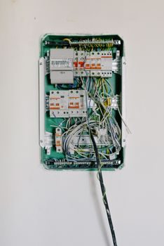 gros plan sur une boîte à fusibles ouverte de véhicule, une pince à fusibles extrayant un fusible du circuit rétroviseurs, étiquette d'identification visible sur le capot du boîtier