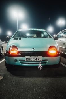 Twingo neuve garée dans un showroom Renault, étiquette de prix visible collée sur le pare-brise, éclairage de concession automobile